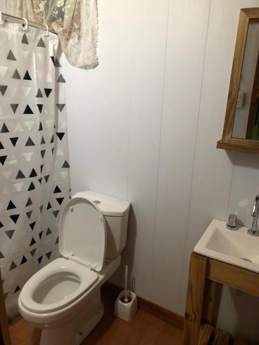 a bathroom with a white toilet and a sink at Cabañas Rosmar in Colón