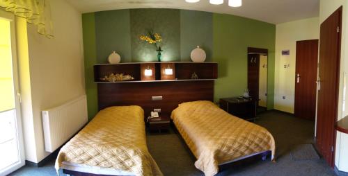 two beds in a room with green walls at Hotel Restauracja Venus in Moderówka