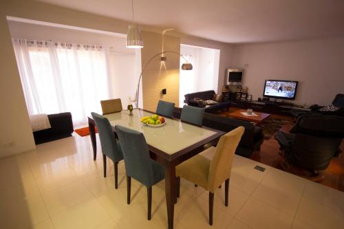 a dining room and living room with a table and chairs at Sands in St Julian's