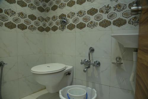 a bathroom with a toilet and a sink at Shree Akshar Restaurant and Hotel in Ahmedabad