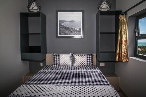 a bedroom with a bed with black and white sheets at Mui Ne Hills Villa Hotel in Mui Ne