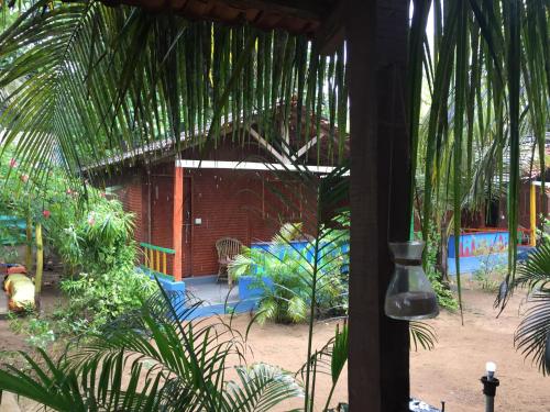 a view of a garden with a house with a palm tree at Secret Garden Arambol in Arambol