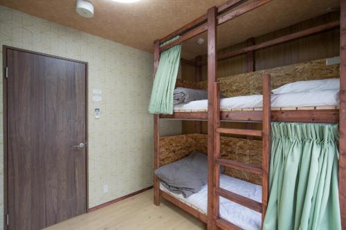 a room with two bunk beds and a door at woodon in Osaka