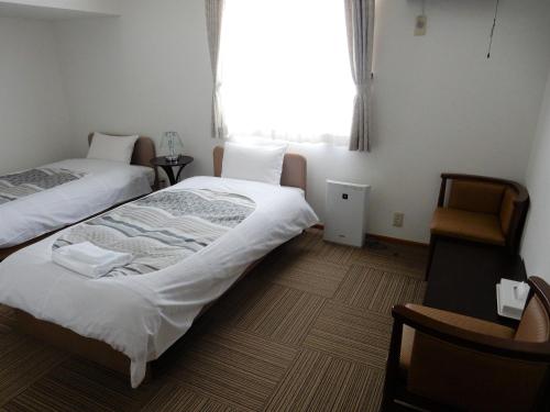 a room with two beds and a window at FURANO B&B in Furano