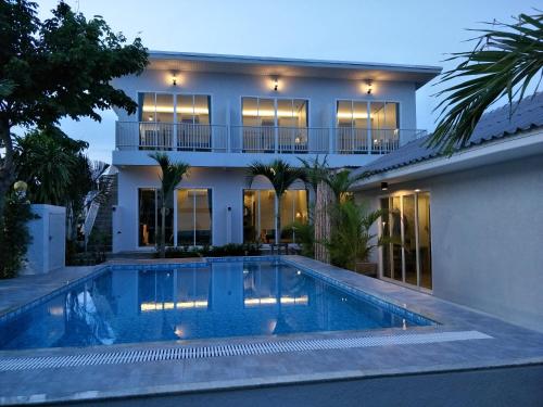 a house with a swimming pool in front of a house at Sea Sand House Resort in Klong Wan