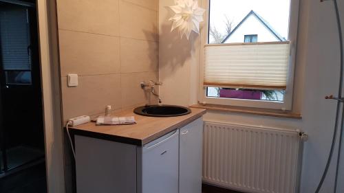 a bathroom with a sink and a window at Zimmervermietung Kolkwitz - Pension Geisler in Kolkwitz