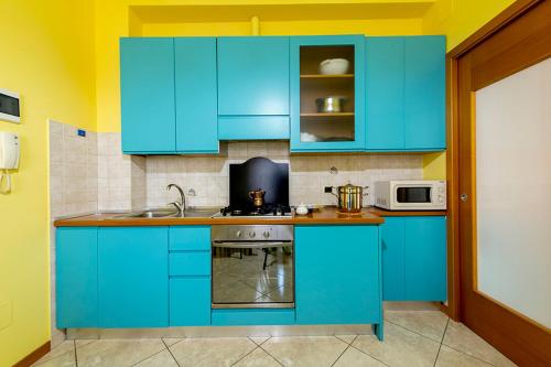 a blue kitchen with a sink and a stove at Hotel Le Soleil in San Benedetto del Tronto