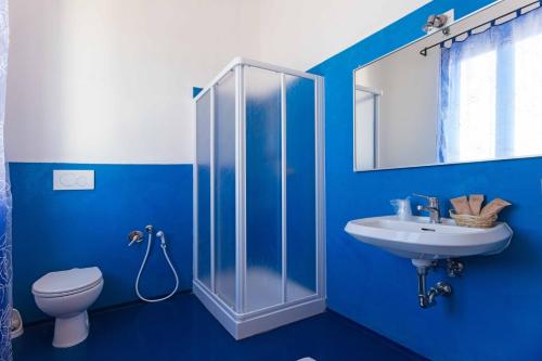 Baño azul con aseo y lavamanos en Hotel Il Ponte, en Cecina