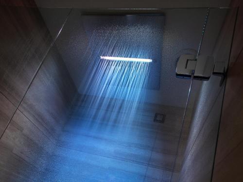 a shower with a beam of light in a bathroom at Hotel Cavour in Milan