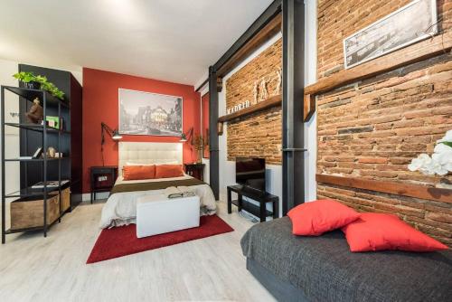 1 dormitorio con 2 camas y pared de ladrillo en Hermoso Estudio en Lavapiés - Wifi, en Madrid