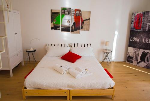 ein Schlafzimmer mit einem großen weißen Bett mit roten Kissen in der Unterkunft La "Piccola" di Irene al Vaticano in Rom