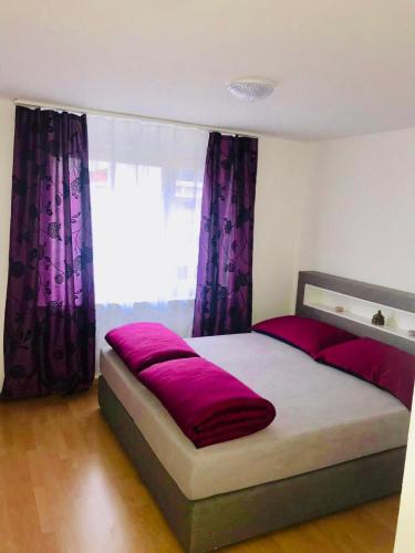 ein Schlafzimmer mit einem großen Bett mit lila Vorhängen in der Unterkunft 3 Room Premium Apartment Buchs SG in Buchs