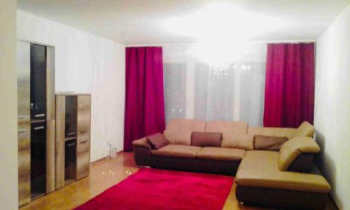 ein Wohnzimmer mit einem Sofa und roten Vorhängen in der Unterkunft 3 Room Premium Apartment Buchs SG in Buchs