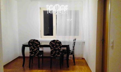 mesa de comedor con 2 sillas y ventana en 3 Room Premium Apartment Buchs SG, en Buchs