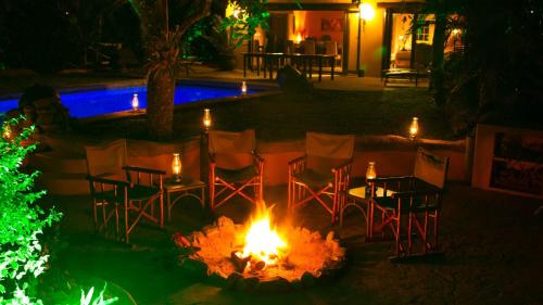 a fire pit with chairs and tables at night at Kwalucia Private Safari Retreat in St Lucia