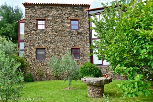 a large brick building with a bird statue in front of it at Casa Lagar Da Alagoa in Manteigas