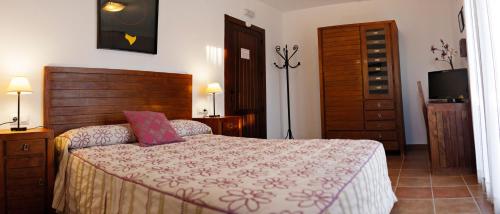 1 dormitorio con 1 cama grande y cabecero de madera en Casa Rural La Loma, en Nohales