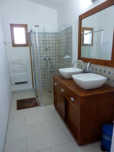 une salle de bain avec deux lavabos et une douche dans l'établissement Coutelon, havre de paix en pleine nature, à Saint-Jurs
