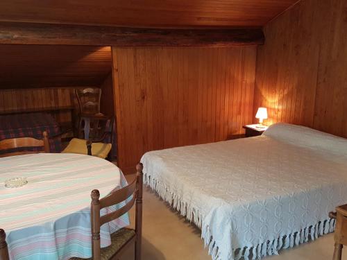 モルジヌにあるLe Cottage 2のベッド2台 木製の壁の部屋