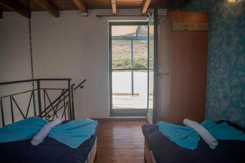 two beds in a room with a window at Villa Afou in Afráta