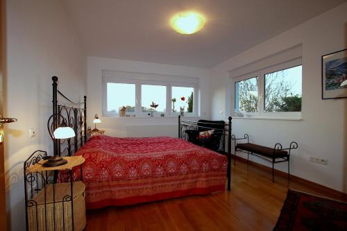 1 dormitorio con 1 cama roja y 2 ventanas en Ferienhaus Vera, en Moritzburg