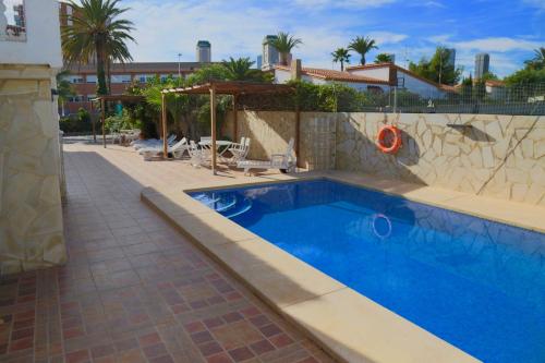 a large blue swimming pool in a yard at Villa Ana Apartments in Benidorm