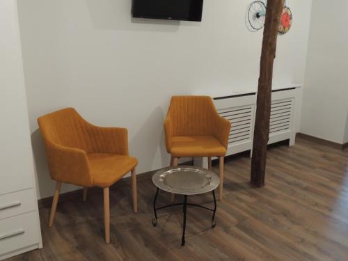 2 sillas y una mesa en una habitación en Hotel La Huella Del Camino en Belorado