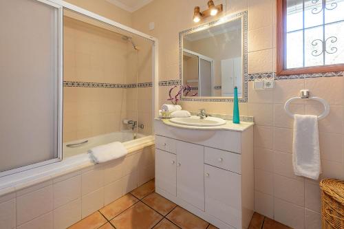 y baño con lavabo, bañera y espejo. en Villa Can Turrent, en Sant Carles de Peralta