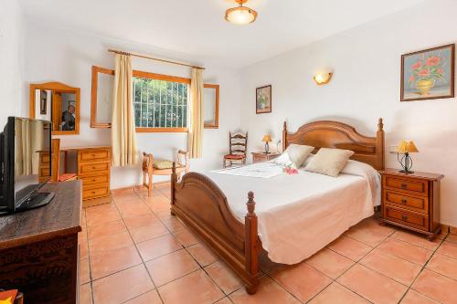 1 dormitorio con 1 cama y TV en una habitación en Villa Can Turrent, en Sant Carles de Peralta