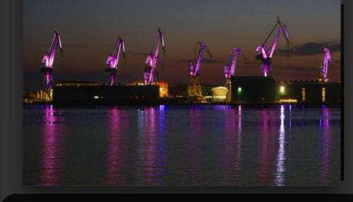 a view of a city with purple lights in the water at Apartment Zdravko in Štinjan