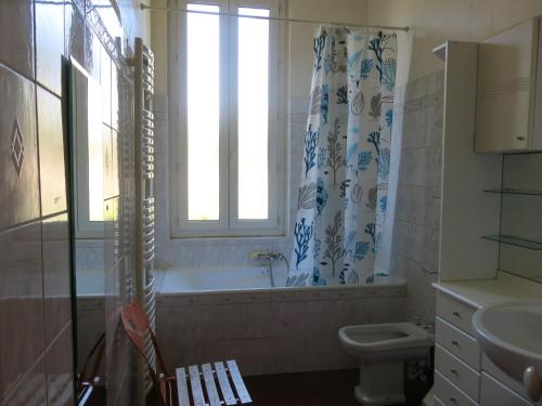 a bathroom with a tub and a toilet and a window at Maison avec jardin sur une colline in Marseille