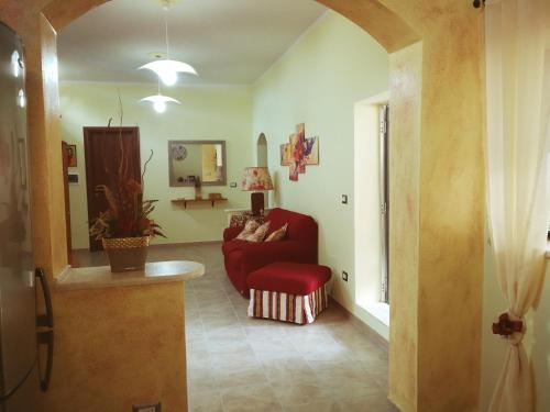 Casa Debby في بورتو توريس: غرفة معيشة مع أريكة حمراء وكرسي