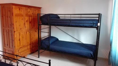 サン・ティジドーロにあるKali Nitta Salentoの二段ベッド2台とキャビネットが備わる客室です。