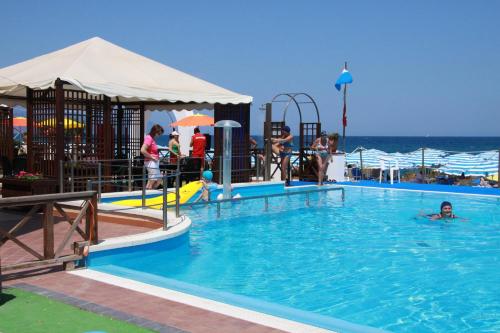 a swimming pool with a person in the water at Sait Hotel & BB in Terme Vigliatore