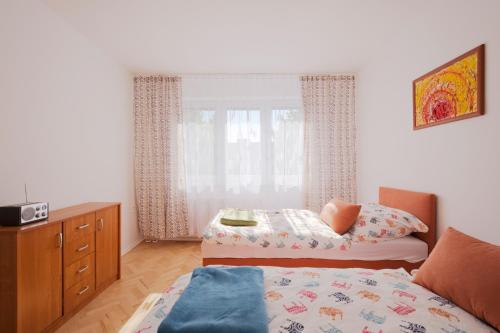 um quarto com uma cama, uma cómoda e uma janela em Terasa Capajevova 6 Kosice em Košice