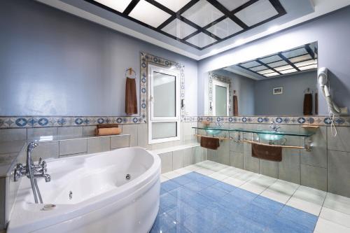 a large bathroom with a tub and a mirror at Holiday Club Jardin Amadores in Amadores