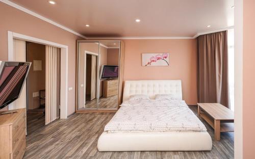 1 dormitorio con cama y espejo grande en Cozy apartment in a new building close to the downtown, en Kiev