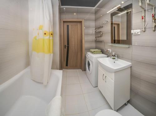 a bathroom with a sink and a washing machine at Cozy apartment in a new building close to the downtown in Kyiv
