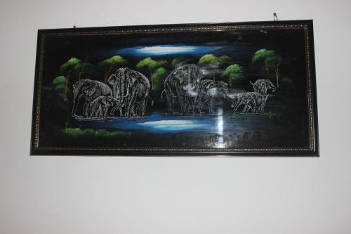 a framed painting of elephants in a forest at Wilpattu Holiday Home in Nochchiyagama