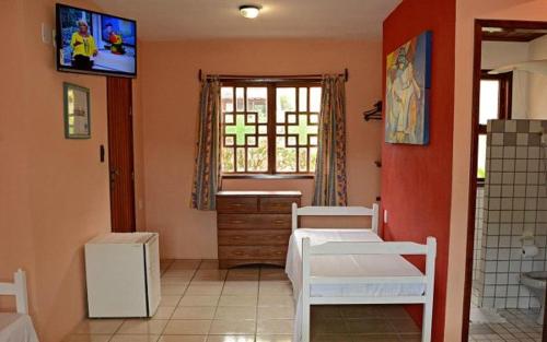 1 dormitorio con 2 camas, ventana y TV en Pousada 4 Ventos, en Arraial d'Ajuda