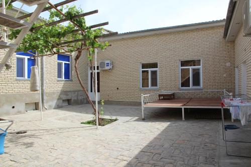 een bank voor een bakstenen gebouw bij Payraviy in Bukhara