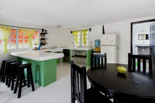 a kitchen with a table and chairs and a refrigerator at Casa Alex 100m from the beach in Tulum