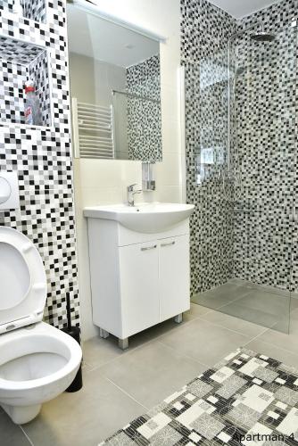 a bathroom with a toilet and a sink and a shower at Vajda Apartments in Novi Sad