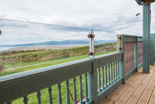 a balcony with a view of the ocean at Enlli Fach pet friendly Cabin , sleeps 2 adults 2 children not suitable for contract workers due to parking in Borth