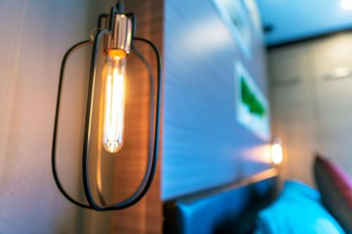 a light that is hanging from a wall at ARMO Nimman in Chiang Mai