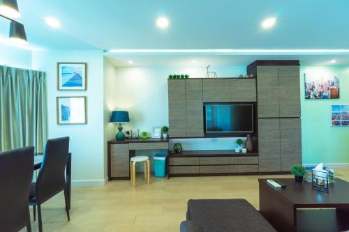 a living room with a flat screen tv on a wall at ARMO Nimman in Chiang Mai