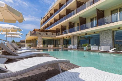 une piscine avec des chaises longues et un hôtel dans l'établissement Main Palace Hotel, à Roccalumera