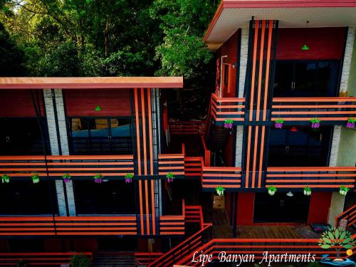 a house with red and orange stripes on it at Lipe Banyan Apartments in Ko Lipe