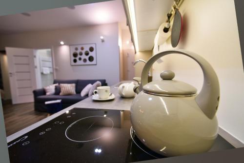 a tea kettle sitting on top of a stove in a kitchen at Apartamenty Sjesta Centrum in Kudowa-Zdrój