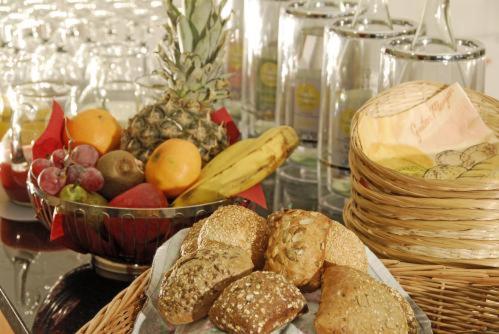 Una mesa con una cesta de pan y un bol de fruta. en Hotel Haus Schons, en Mettlach